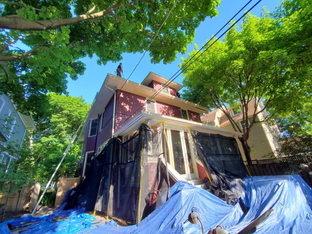 house protected with tarps and netting by evanston roofing contractor